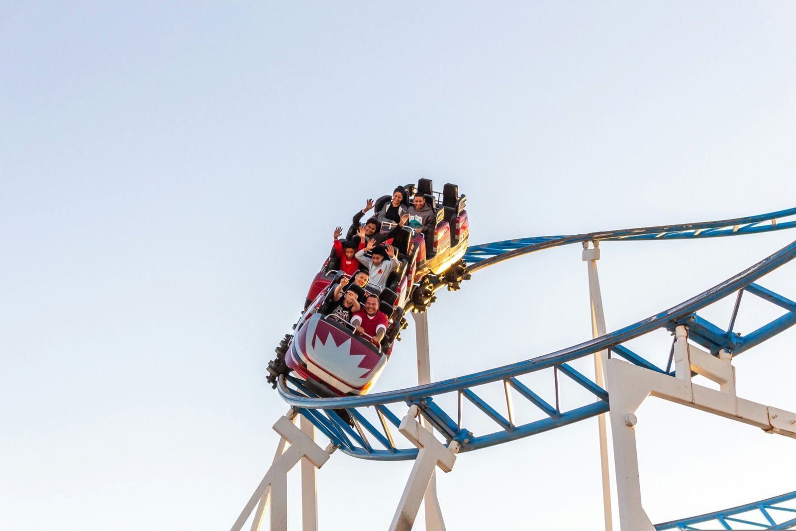 people riding roller coaster during daytime